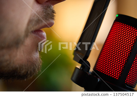 Close up of man speaking into microphone with pop filter Close up of man speaking into microphone with pop filter 137504517