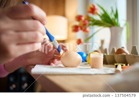 Woman painting Easter egg at home with pastel paints Woman painting Easter egg at home with pastel paints 137504579