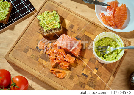 Avocado toast with smoked salmon on wooden cutting board Avocado toast with smoked salmon on wooden cutting board 137504580