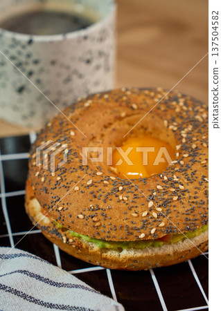 Avocado bagel breakfast sandwich with egg and coffee Avocado bagel breakfast sandwich with egg and coffee 137504582