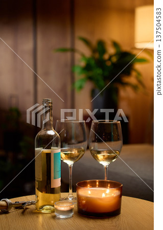 Bottle of white wine with two glasses and candles at home Bottle of white wine with two glasses and candles at home 137504583