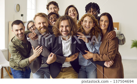 Group of a happy smiling business people looking at camera, having fun and hugging in office. 137504694