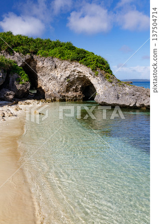 清澈的海水和岩石拱門構成了一片海灘。 清澈的海水和岩石拱門構成了一片海灘。 137504714