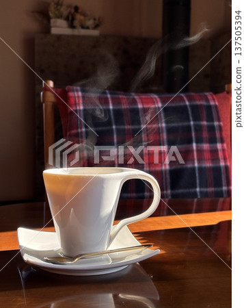 晨光灑在桌上,旁邊放著一杯熱咖啡。 晨光灑在桌上,旁邊放著一杯熱咖啡。 137505394