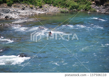 一名男子在釣香魚 一名男子在釣香魚 137506110