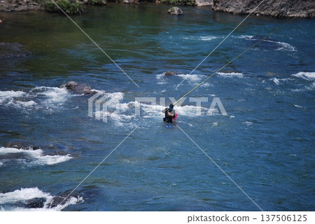 一名男子在釣香魚 一名男子在釣香魚 137506125