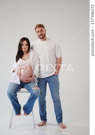 Expecting parents pose together in a cozy studio Expecting parents pose together in a cozy studio 137506272