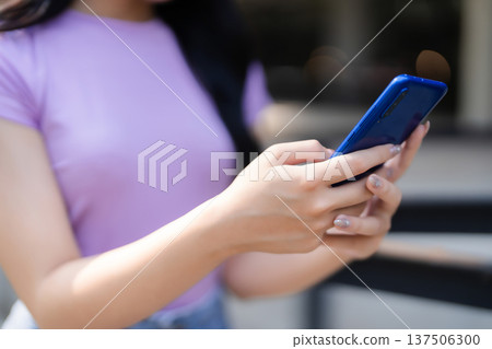 Asian adult female hands using smartphone outdoor interacting digital content mobile communication technology modern lifestyle connecting digital world everyday activity Asian adult female hands using smartphone outdoor interacting digital content mobile communication technology modern lifestyle connecting digital world everyday activity 137506300