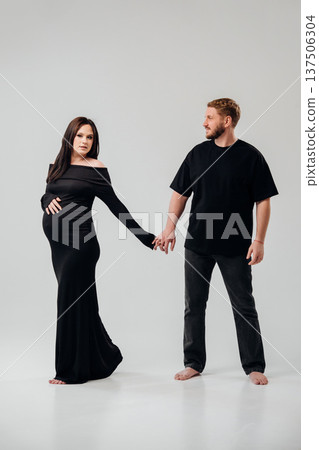 Couple holding hands in studio before expecting baby Couple holding hands in studio before expecting baby 137506304