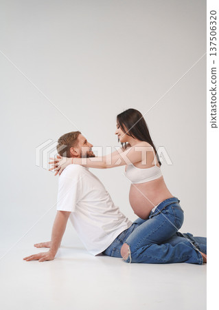 Couple joyfully celebrating pregnancy in a studio setting 137506320