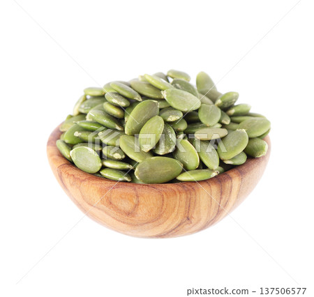 Pumpkin seeds isolated on white background. Green peeled pumpkin seeds in wooden bowl. Clipping path. Pumpkin seeds isolated on white background. Green peeled pumpkin seeds in wooden bowl. Clipping path. 137506577