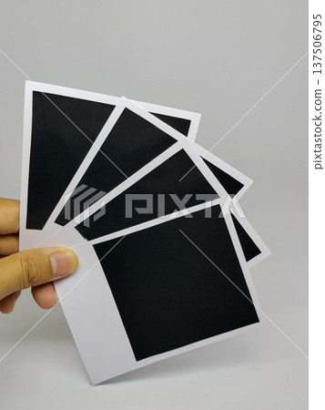 Black and white photo frames in hand on grey background. Isolated Black and white photo frames in hand on grey background. Isolated 137506795