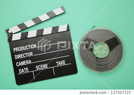 Movie clapper with popcorn and film reels on mint background Movie clapper with popcorn and film reels on mint background 137507135