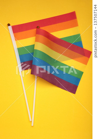 LGBT rainbow flag flat lay on yellow background. Space for text. Vertical photo LGBT rainbow flag flat lay on yellow background. Space for text. Vertical photo 137507144