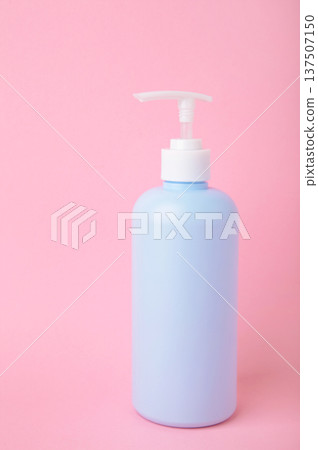 Blue glass liquid soap dispenser on pink background. Vertical photo Blue glass liquid soap dispenser on pink background. Vertical photo 137507150