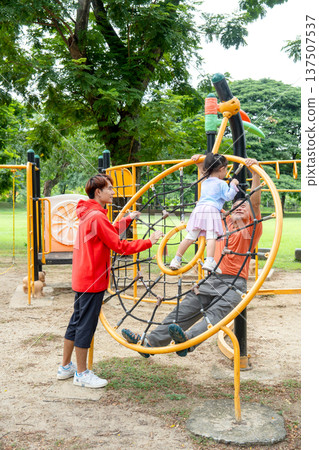 Vertical image of Asian little girl enjoy to play in playground and smile also play with grandfather and they look happy with the family activity. Vertical image of Asian little girl enjoy to play in playground and smile also play with grandfather and they look happy with the family activity. 137507537