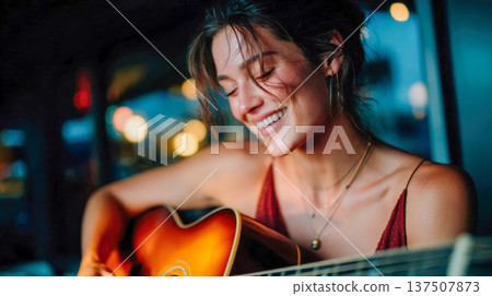 Young woman playing acoustic guitar in warm light, intimate music performance and creative lifestyle portrait 137507873