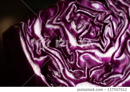 Close-up of a halved red cabbage showcasing its vibrant purple colour and intricate leaf patterns. The texture is detailed and fresh, ideal for culinary themes. Close-up of a halved red cabbage showcasing its vibrant purple colour and intricate leaf patterns. The texture is detailed and fresh, ideal for culinary themes. 137507912