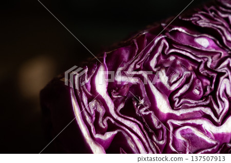Close-up of a halved red cabbage showcasing its vibrant purple colour and intricate leaf patterns. The texture is detailed and fresh, ideal for culinary themes. Close-up of a halved red cabbage showcasing its vibrant purple colour and intricate leaf patterns. The texture is detailed and fresh, ideal for culinary themes. 137507913