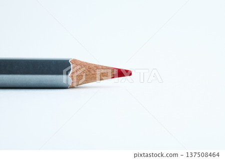 A single grey-barreled red colored pencil lying horizontally on a bright white surface A single grey-barreled red colored pencil lying horizontally on a bright white surface 137508464