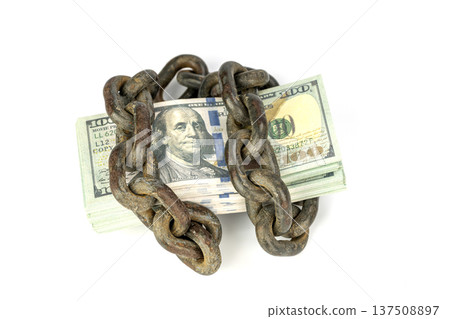 Tightly Bound Hundred Dollar Bills Enclosed by Heavy Chains Symbolizing Financial Restraint and Economic Limitations isolated on white 137508897