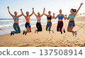 Happy women jump together on beach. Women celebrate teamwork during beach workout, women empowerment concept for womensday campaign, summer fitness retreat, sunrise light, copy space 137508914