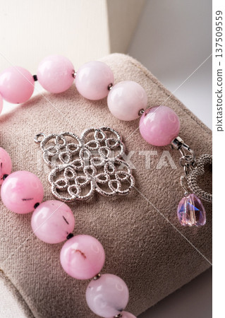 author bracelet with natural cherry jasper and details against white background. fashion and jewelry concept author bracelet with natural cherry jasper and details against white background. fashion and jewelry concept 137509559