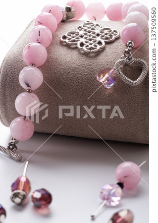 author bracelet with natural cherry jasper and details against white background. fashion and jewelry concept author bracelet with natural cherry jasper and details against white background. fashion and jewelry concept 137509560