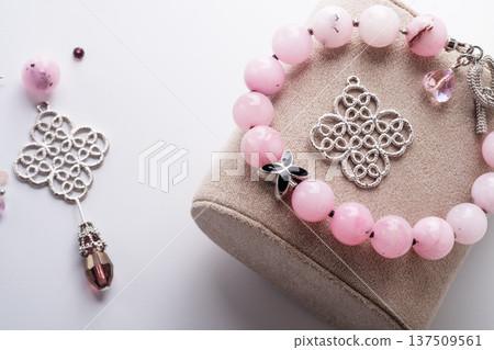 author bracelet with natural cherry jasper and details against white background. fashion and jewelry concept author bracelet with natural cherry jasper and details against white background. fashion and jewelry concept 137509561