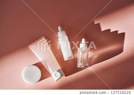 Skincare cosmetic products on pink background casting shadows Skincare cosmetic products on pink background casting shadows 137510228