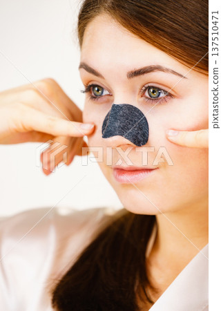 Woman applying pore strips on nose 137510471
