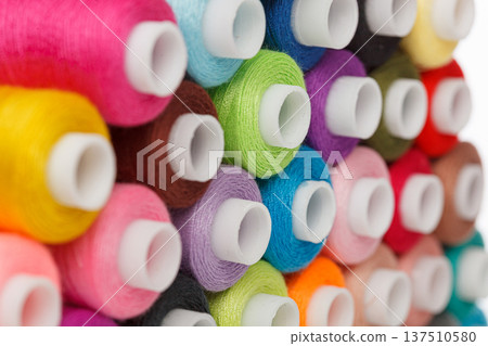 multi-colored spools of sewing thread on a white background multi-colored spools of sewing thread on a white background 137510580