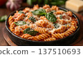 Delicious plate of spiral pasta topped with fresh basil, grated cheese, and a rich tomato sauce, served in a rustic black dish, showcasing culinary artistry and vibrant colors 137510693