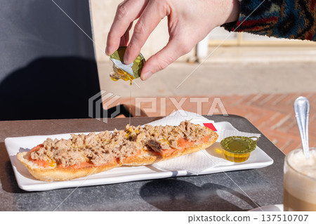 Man drizzling tostada with olive oil. Spanish breakfast. 137510707
