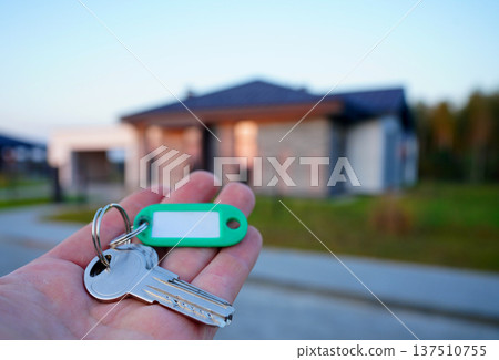 Buying home. Hand holding a bunch of keys at modern private home. Concept of buying real estate 137510755