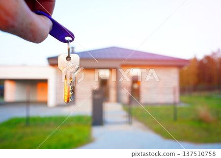 Buying home. Hand holding a bunch of keys at modern private home. Concept of buying real estate Buying home. Hand holding a bunch of keys at modern private home. Concept of buying real estate 137510758