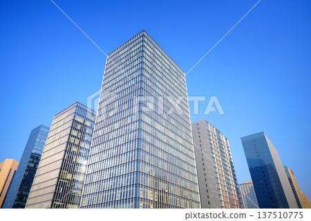 Glass tower building on blue sky background. Facade of new modern business office building. Glass tower building on blue sky background. Facade of new modern business office building. 137510775