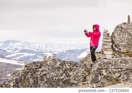 Tourist taking photo from Dalsnibba viewpoint Norway 137510884