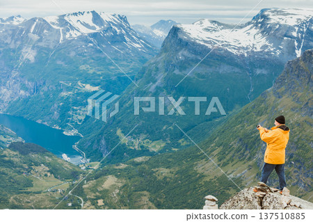 Tourist taking photo from Dalsnibba viewpoint Norway 137510885