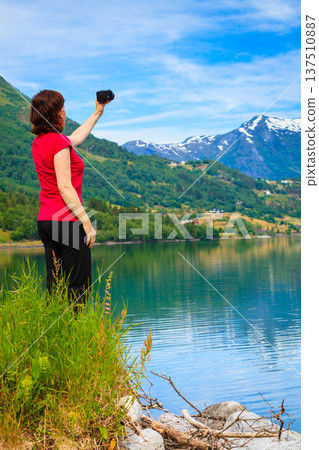 Tourist taking photo at norwegian fjord 137510887
