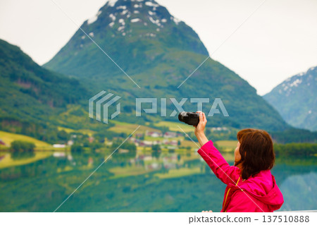 Tourist taking photo at norwegian fjord lake 137510888