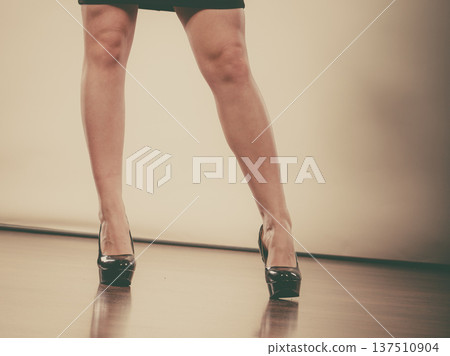 Woman wearing black high heels and dark skirt 137510904