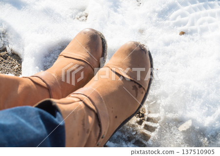 Somebody legs with warm winter shoes on snow 137510905
