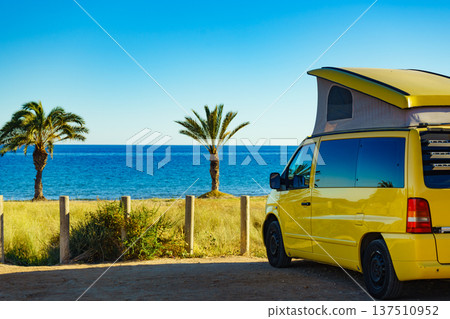 Camper van with tent on roof on beach 137510952
