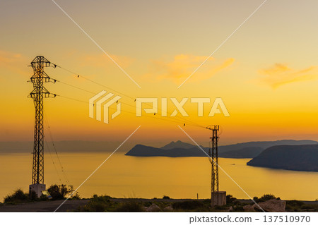 High voltage towers on coast at sunset High voltage towers on coast at sunset 137510970