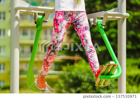 Girl doing legs exercises in outdoor gym 137510971