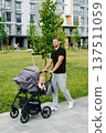 Handsome Young Father Walking with Baby in Stroller in Modern City Park 137511059