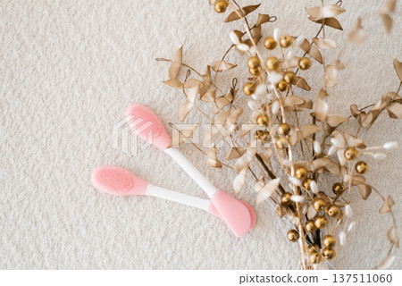 Pink Silicone Facial Brushes Near Decorative Branch Pink Silicone Facial Brushes Near Decorative Branch 137511060