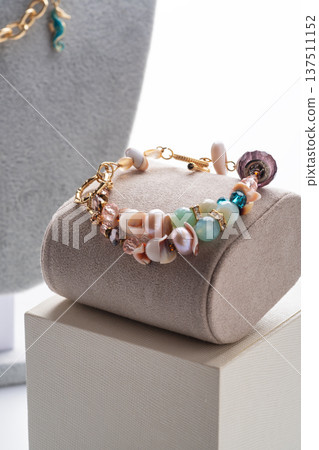 author gold plated bracelete with pearls and gemstones demonstrated against white background. fashion and jewelry concept author gold plated bracelete with pearls and gemstones demonstrated against white background. fashion and jewelry concept 137511152
