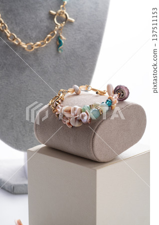 author gold  plated bracelete with pearls and gemstones demonstrated against white background. fashion and jewelry concept 137511153